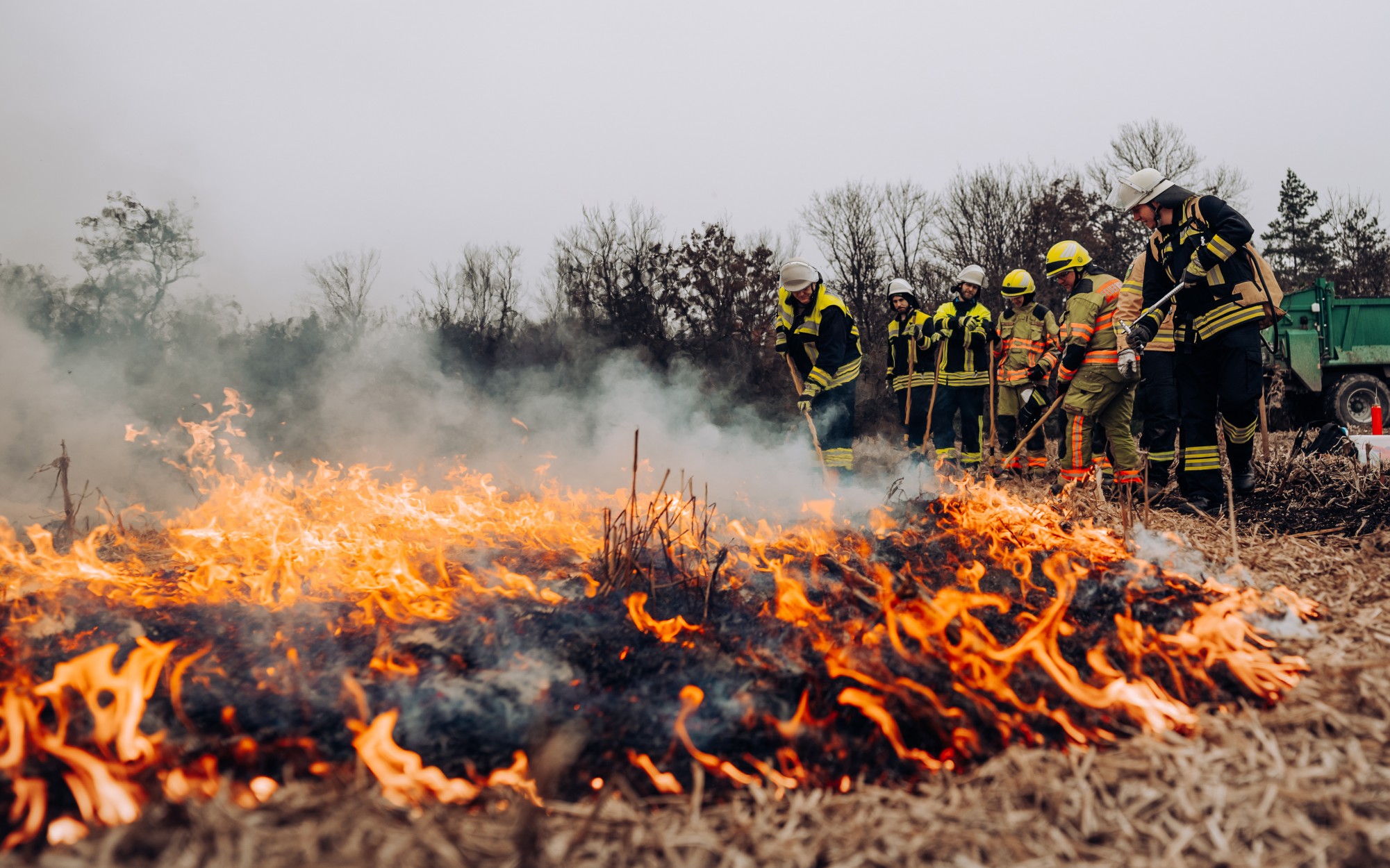 Einsatzkräfte bekämpfen einen Flächenbrand auf einem Feld