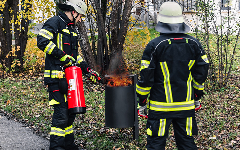 Mülleimerbrand wird mit Feuerlöscher bekämpft