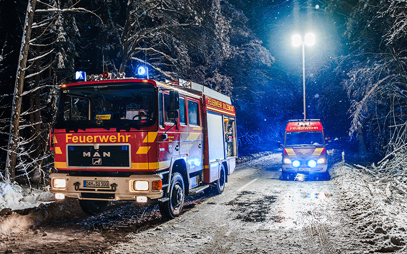  Zwei Feuerwehrfahrzeuge auf einer verschneiten Straße