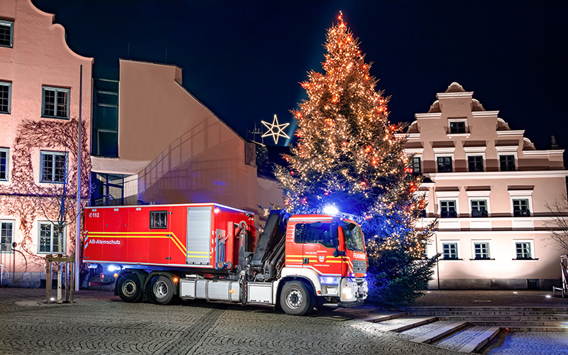 Ein Feuerwehrfahrzeug vor einem Weihnachtsbaum am Dachauer Rathaus
